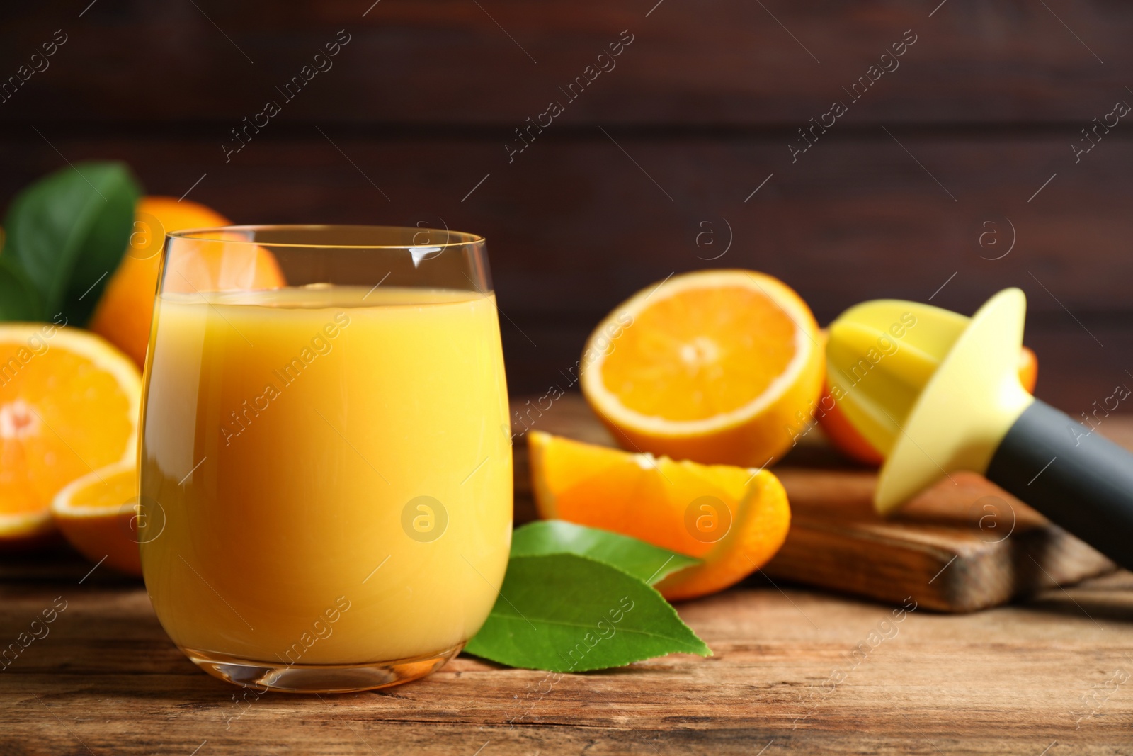 Photo of Glass of orange juice and fresh fruits on wooden table, closeup