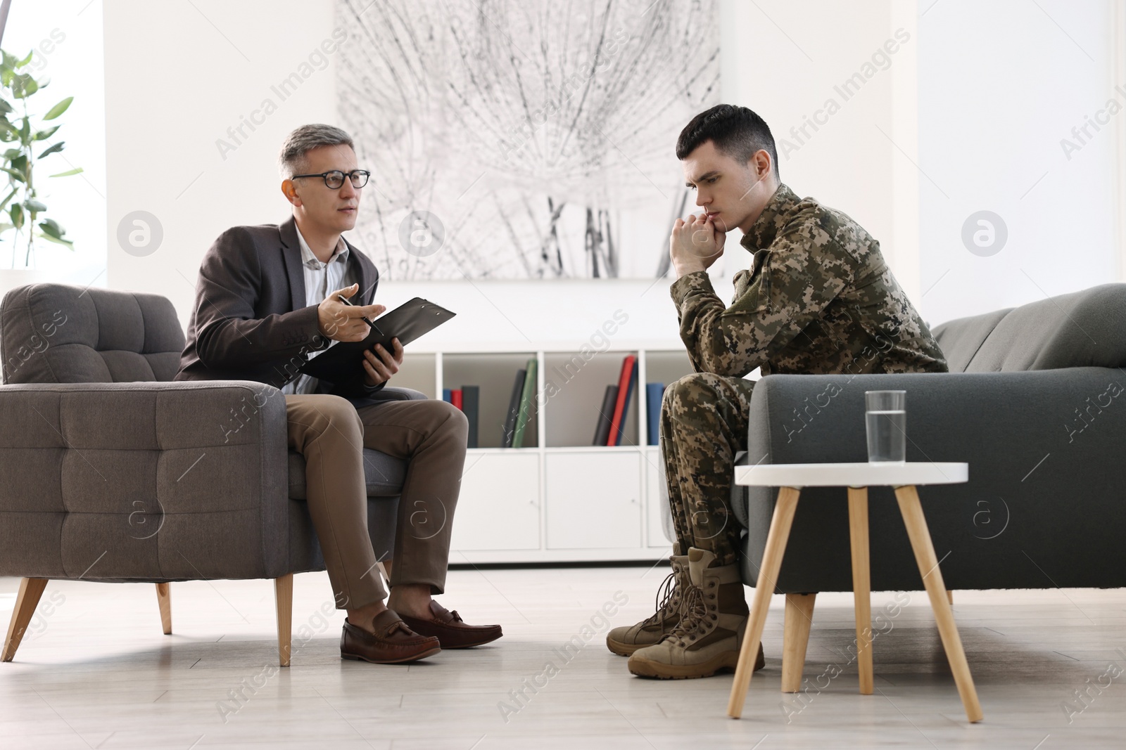 Photo of Professional psychotherapist working with military man in office