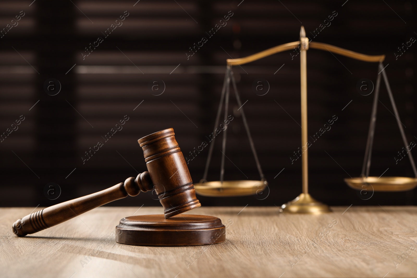 Photo of Wooden gavel and scales of justice on table. Space for text