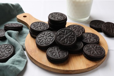 Photo of Board with tasty sandwich cookies on white table, closeup