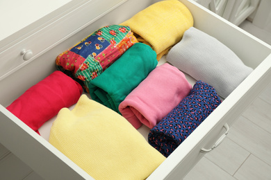 Photo of Folded clothes in open drawer. Apparel storage