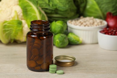 Bottle of pills and foodstuff on white wooden table. Prebiotic supplements