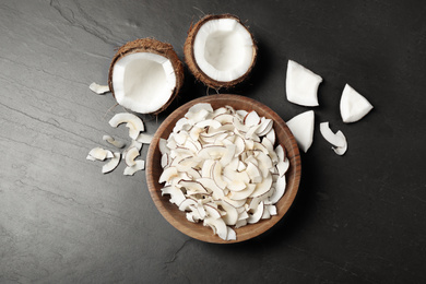 Photo of Flat lay composition with tasty coconut chips on black  table