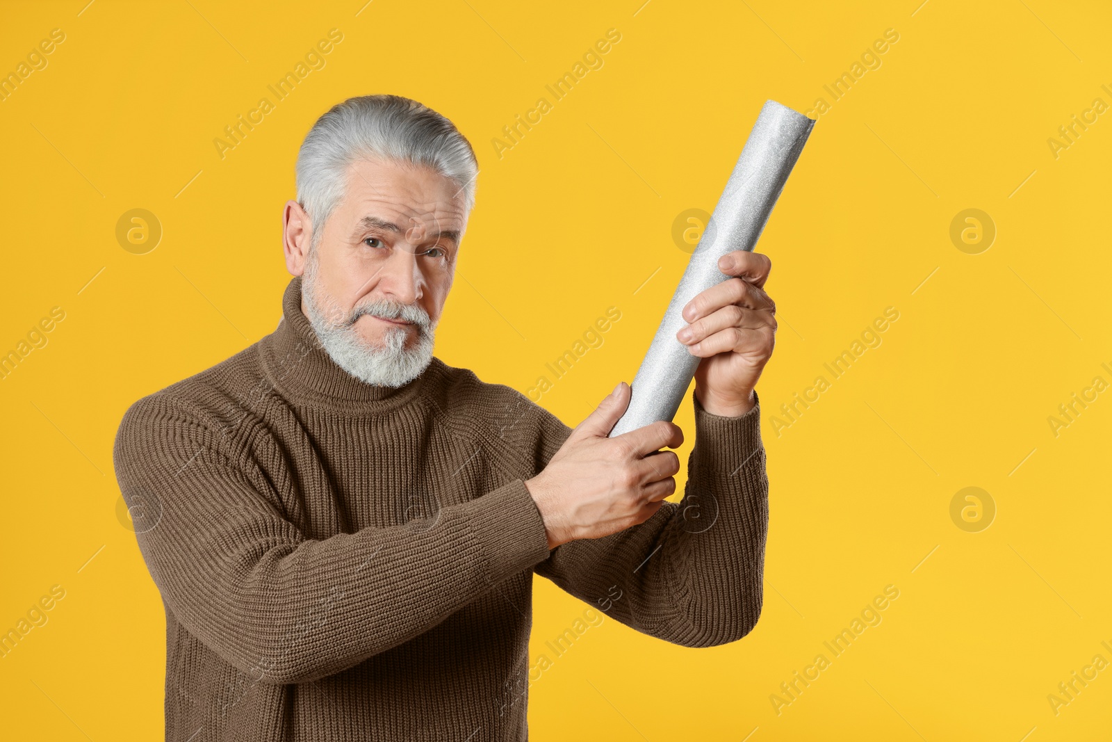 Photo of Man with party popper on yellow background