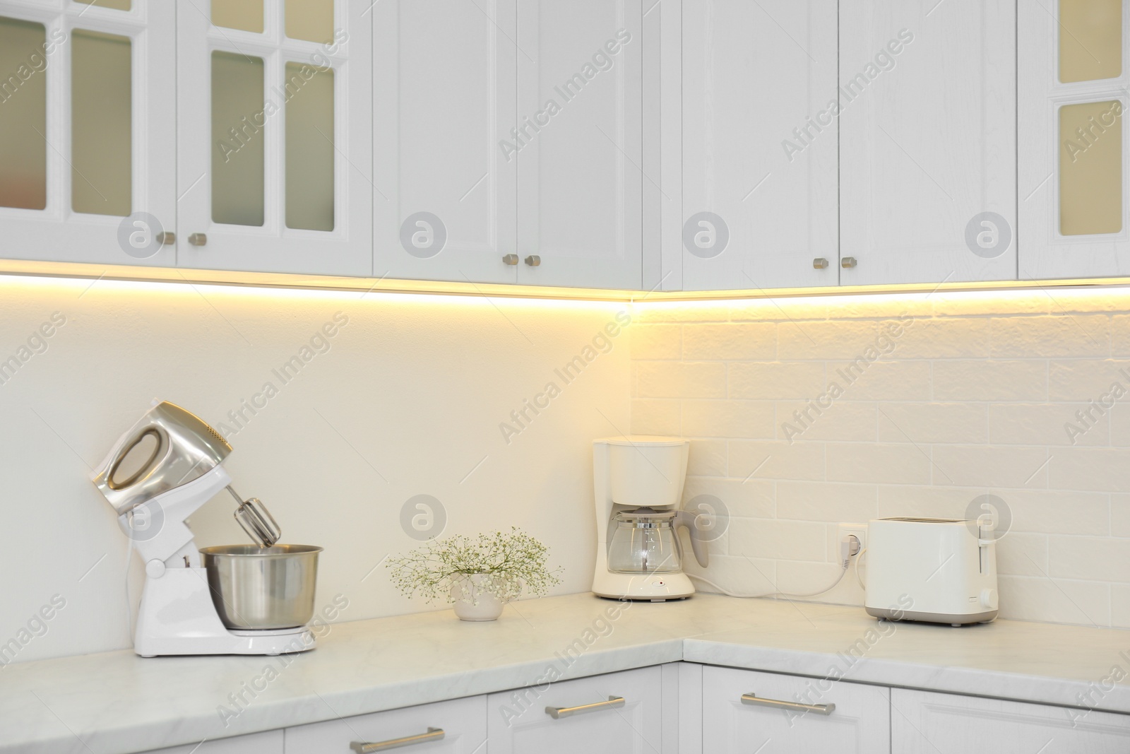 Photo of Modern toaster and household appliances on counter in kitchen