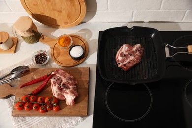 Photo of Frying pan with fresh raw meat on stove, above view