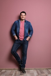 Photo of Portrait of confident young man on color wall background