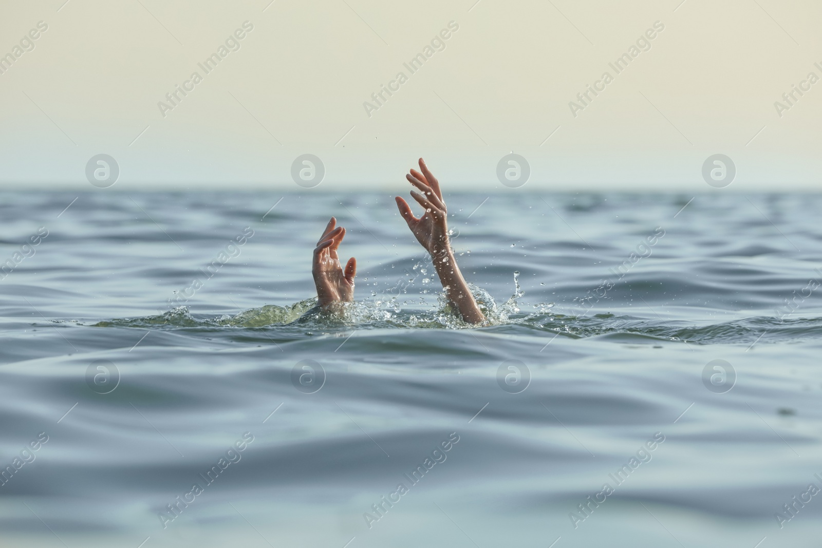 Photo of Drowning woman reaching for help in sea