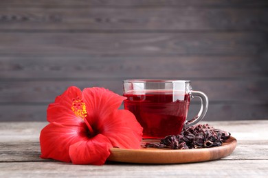 Delicious hibiscus tea and flowers on wooden table