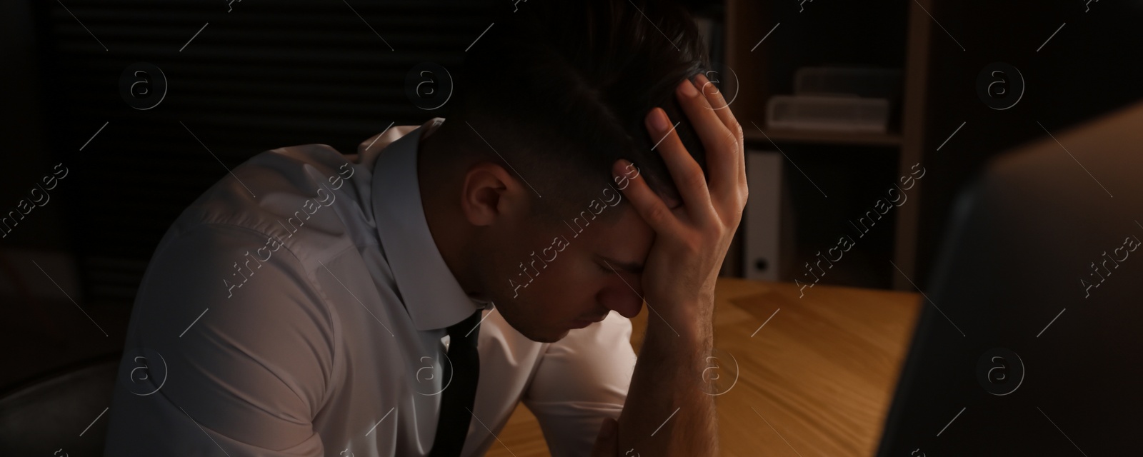 Image of Tired businessman stressing out at workplace late in evening. Banner design