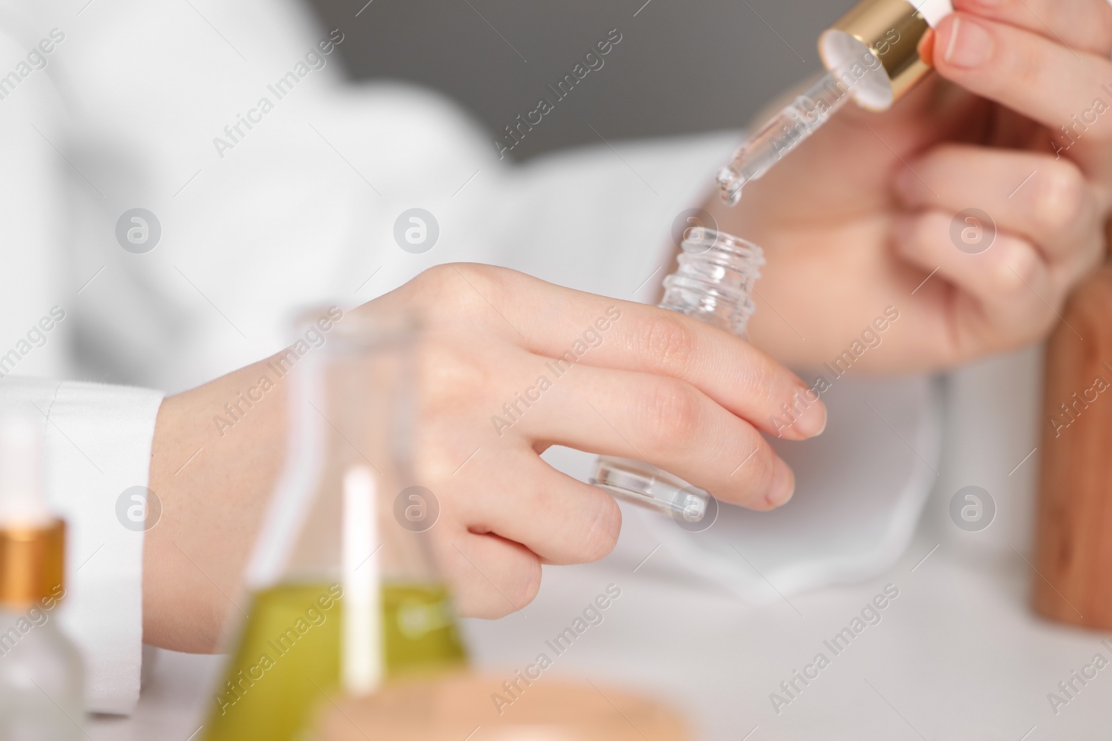 Photo of Dermatologist testing essential oil indoors, selective focus