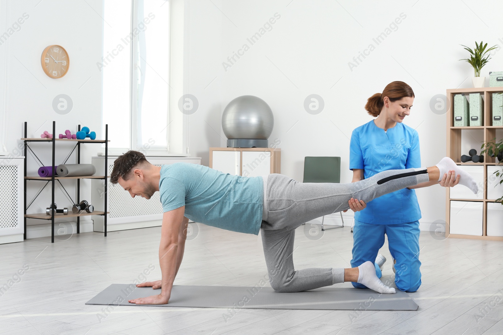 Photo of Physiotherapist working with patient in clinic. Rehabilitation therapy