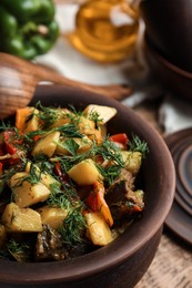 Photo of Tasty cooked dish with potatoes in earthenware, closeup