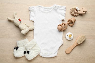 Cute baby stuff on wooden background, flat lay