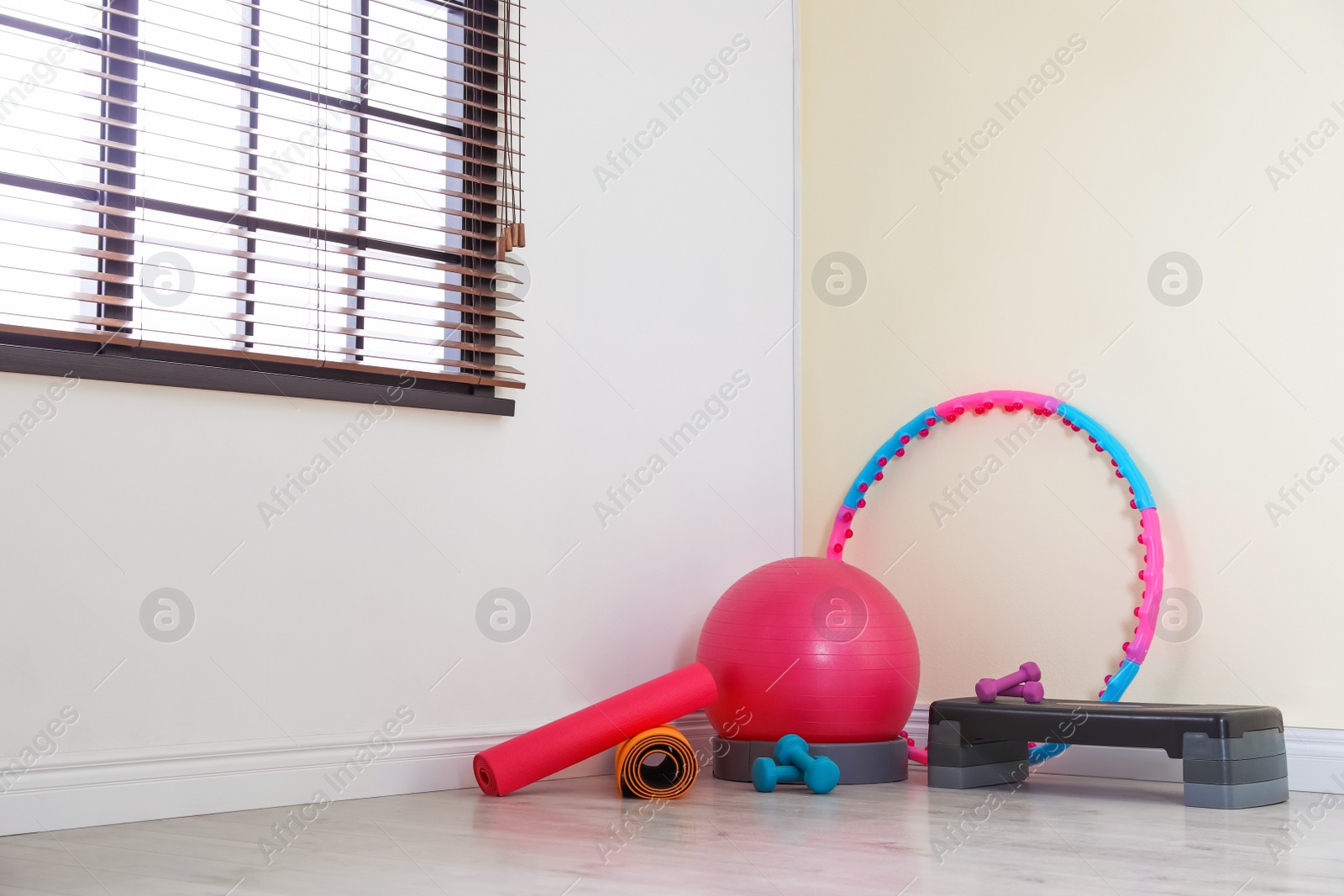 Photo of Different sports equipment near color wall in gym