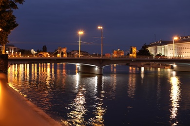 Beautiful view of illuminated city near river at night