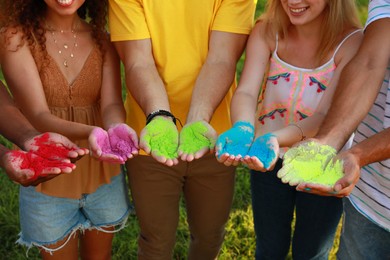 Friends with colorful powder dyes outdoors, closeup. Holi festival celebration