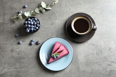 Flat lay composition with piece of tasty blueberry cake on gray table