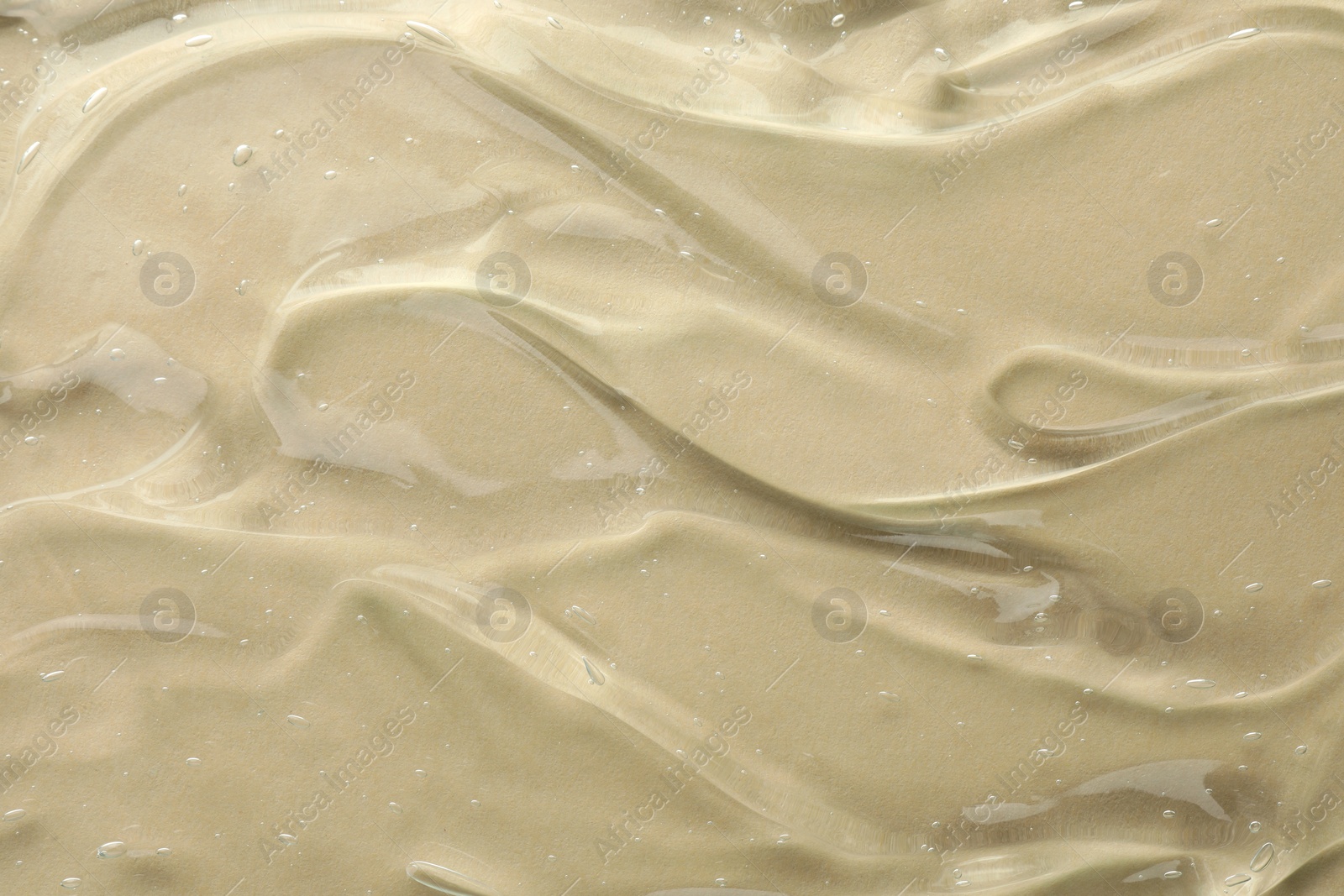 Photo of Clear cosmetic gel on beige background, top view