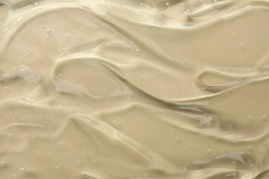 Clear cosmetic gel on beige background, top view