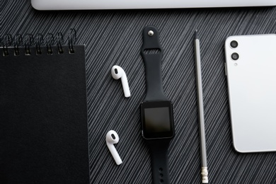 Photo of Flat lay composition with stylish smart watch on black table