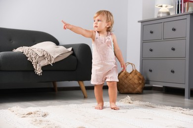 Photo of Cute baby learning to walk in living room