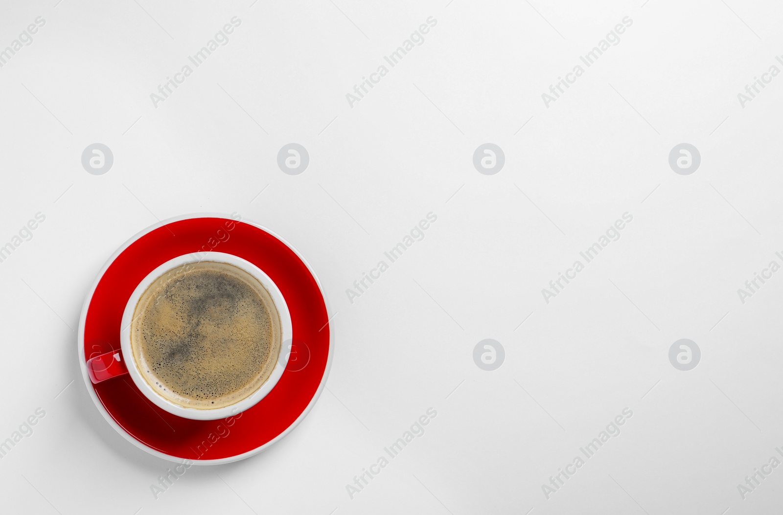 Photo of Red ceramic cup with hot aromatic coffee isolated on white, top view