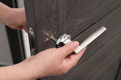 Handyman repairing door handle indoors, closeup view