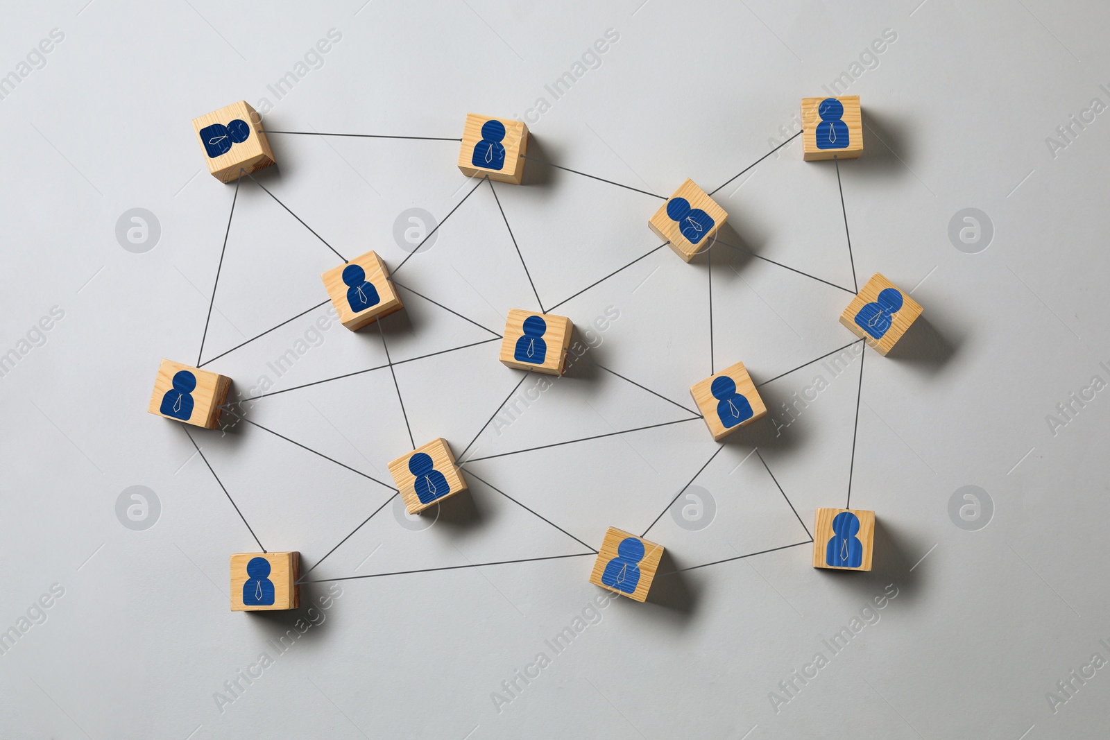 Image of Teamwork. Wooden cubes with human icons linked together symbolizing cooperation on grey background, top view
