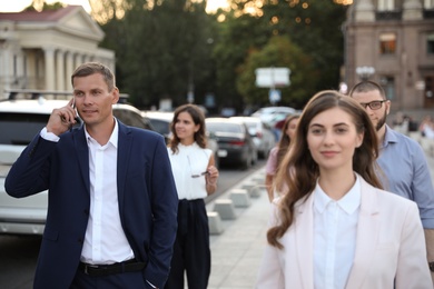 Different people walking on modern city street