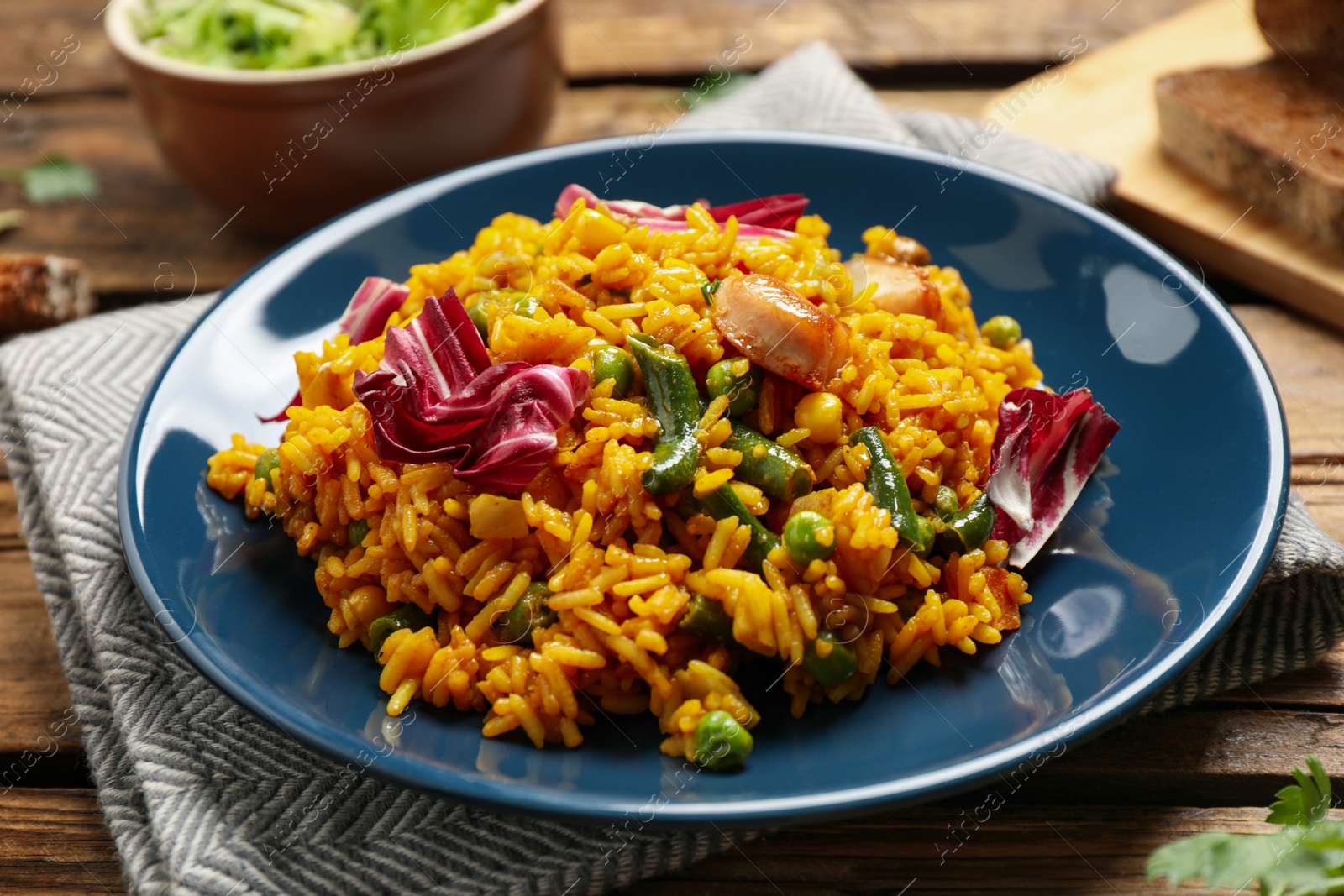 Photo of Delicious rice pilaf with chicken and vegetables on wooden table