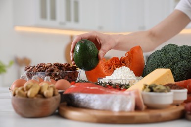 Photo of Woman and healthy food at white table, closeup. Keto diet