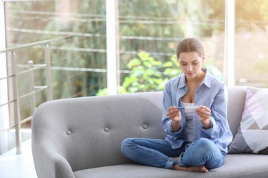 Photo of Young woman with pregnancy test at home. Gynecology