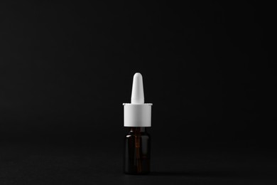 Bottle of nasal spray on black background