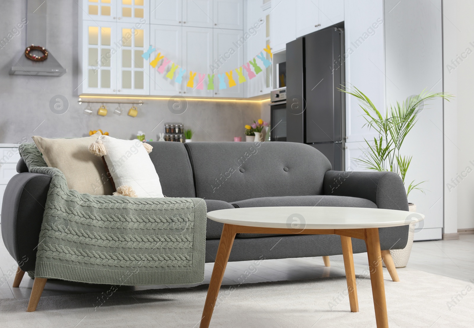 Photo of Gray sofa and white wooden table in kitchen