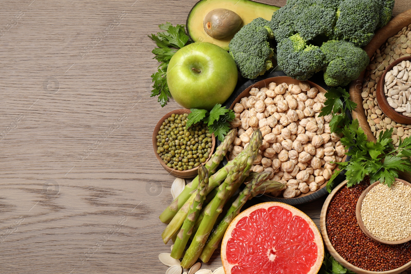 Photo of Fresh vegetables, fruits and seeds on wooden table, flat lay. Space for text