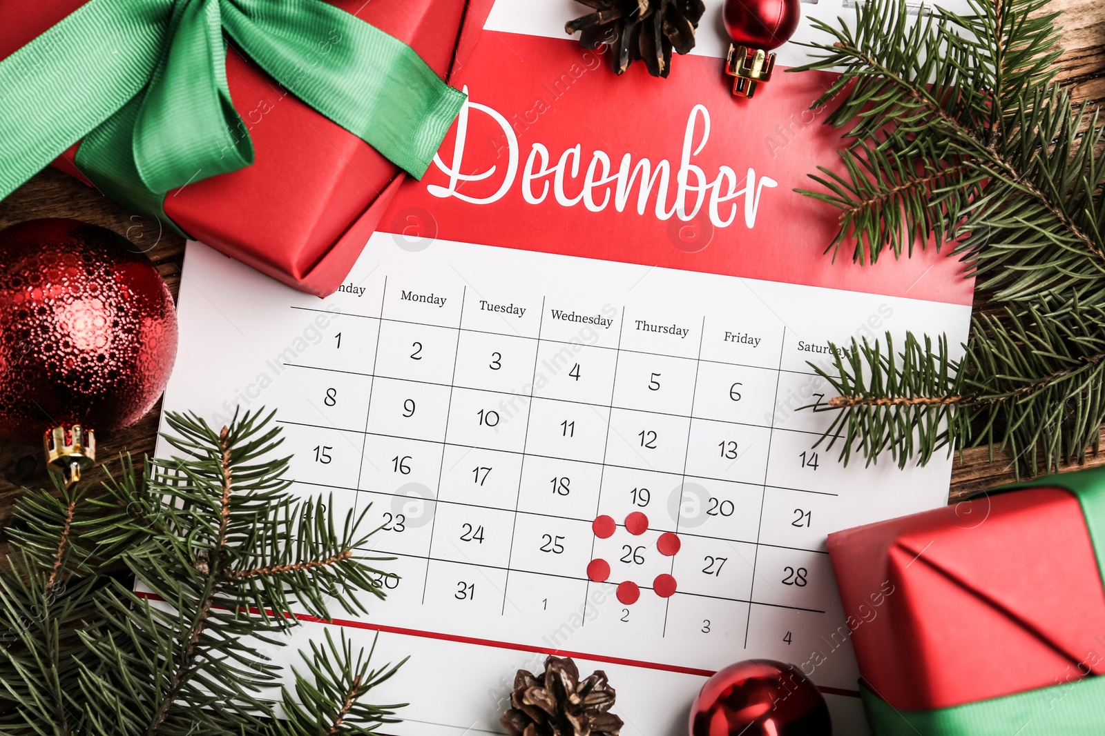 Photo of Flat lay composition with calendar and gifts on wooden table. Boxing day