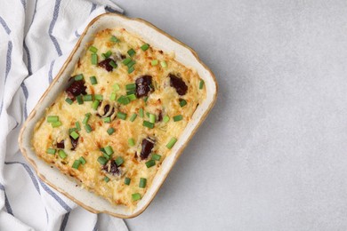 Photo of Tasty sausage casserole with green onions in baking dish on white table, top view. Space for text