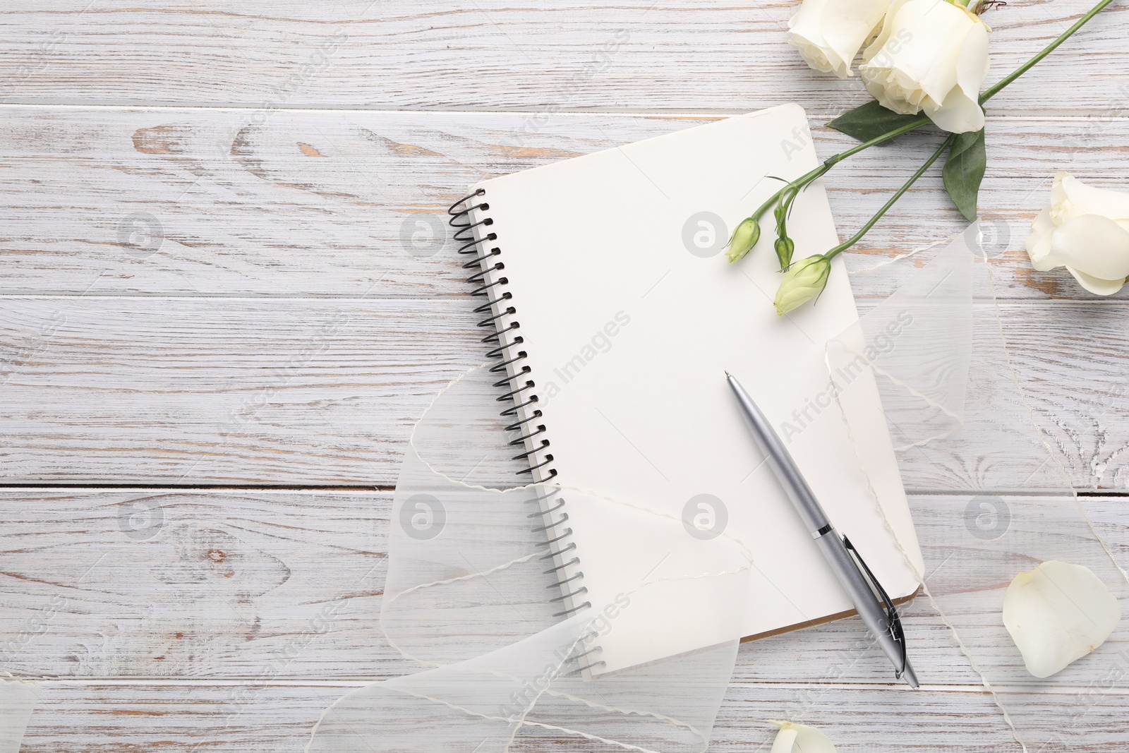 Photo of Guest list. Notebook, pen, rose flowers and ribbon on wooden background, flat lay. Space for text