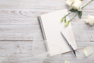 Photo of Guest list. Notebook, pen, rose flowers and ribbon on wooden background, flat lay. Space for text