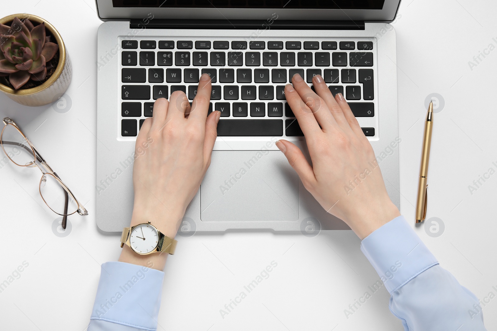 Photo of Woman using laptop at white table, top view