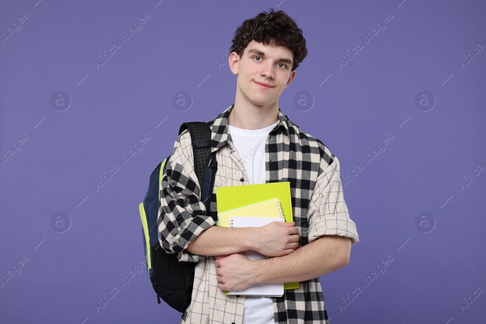 Photo of Portrait of student with backpack and notebooks on purple background