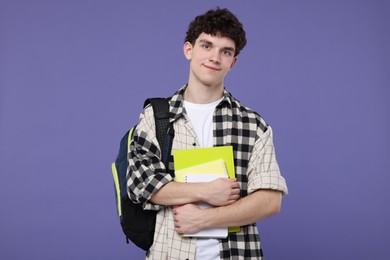 Photo of Portrait of student with backpack and notebooks on purple background