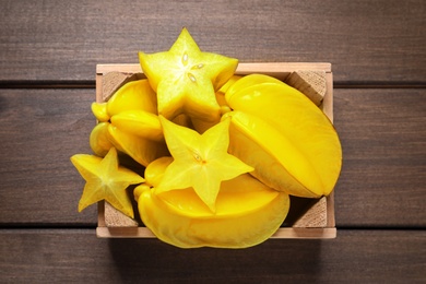 Photo of Delicious carambola fruits on wooden table, top view