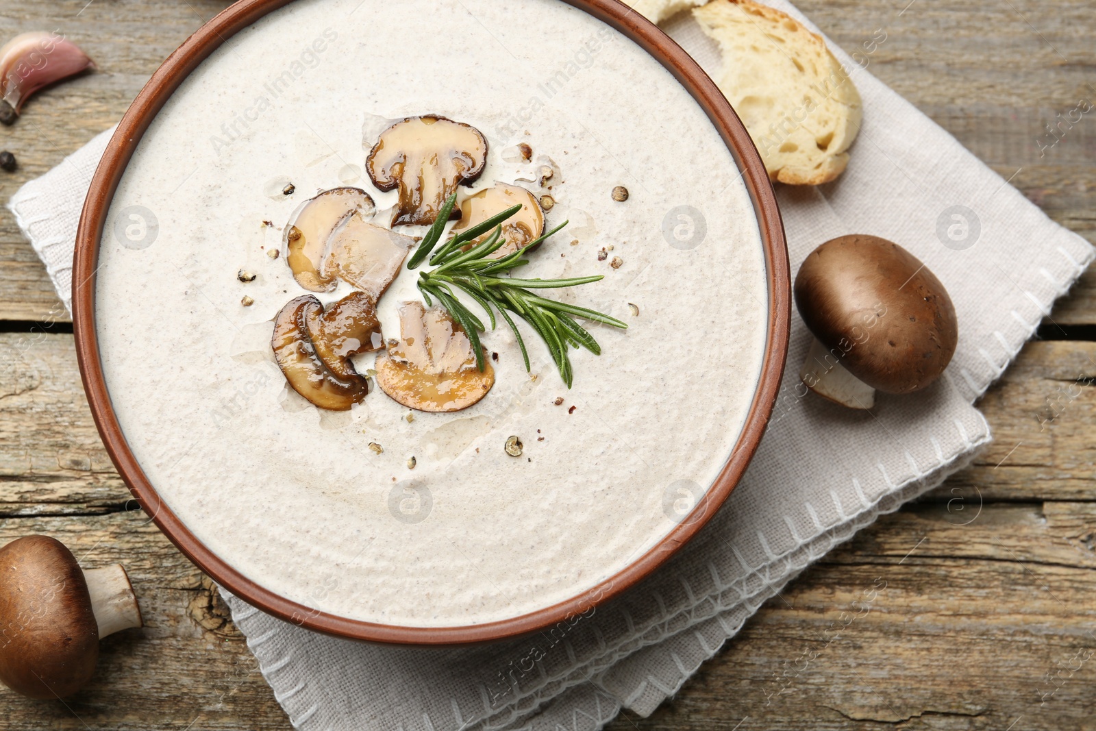 Photo of Fresh homemade mushroom soup in ceramic bowl on wooden table, flat lay