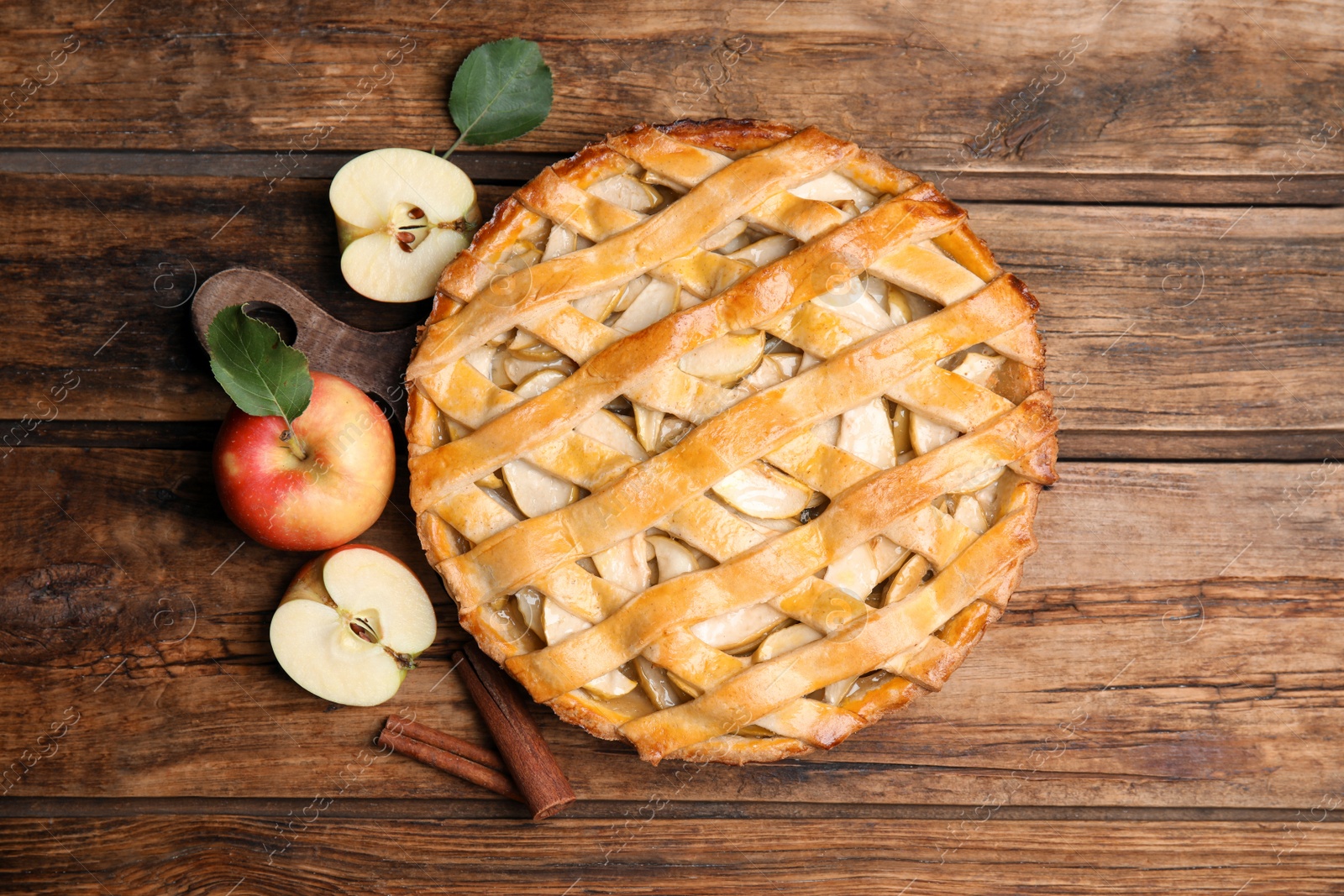 Photo of Delicious traditional apple pie on wooden table, flat lay