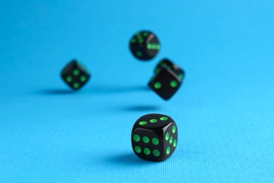 Photo of Many black game dices on light blue background