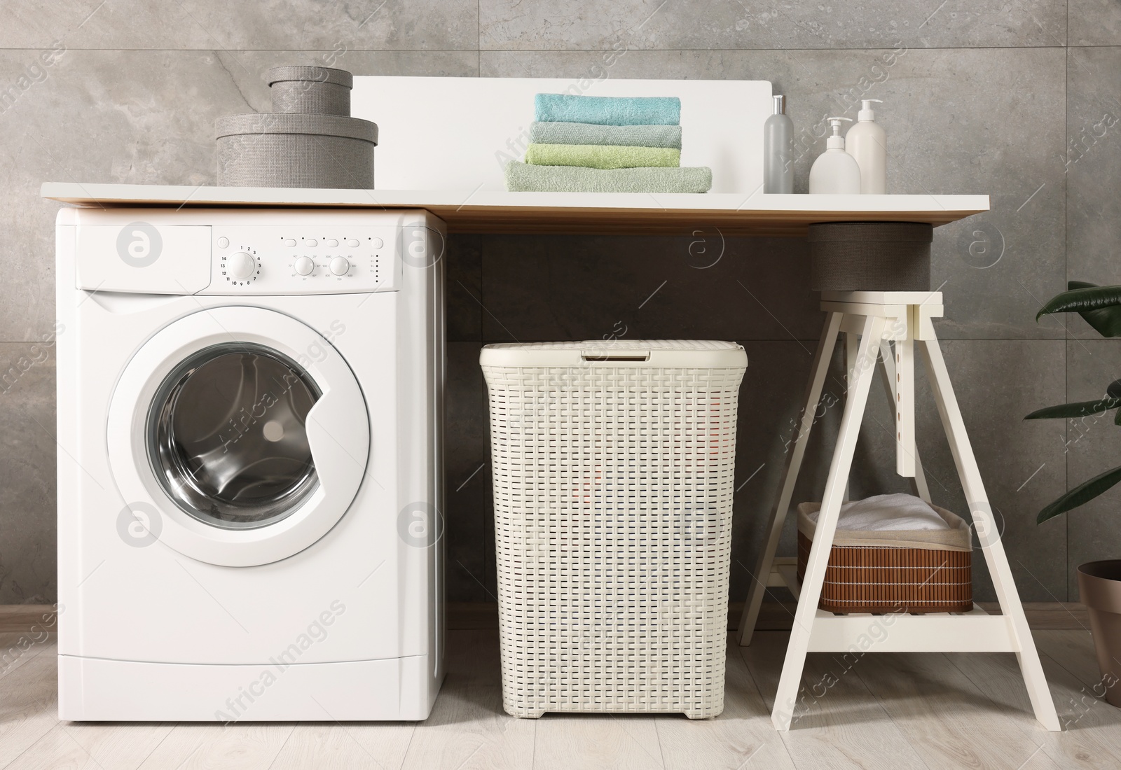 Photo of Stylish laundry room with modern washing machine. Interior design