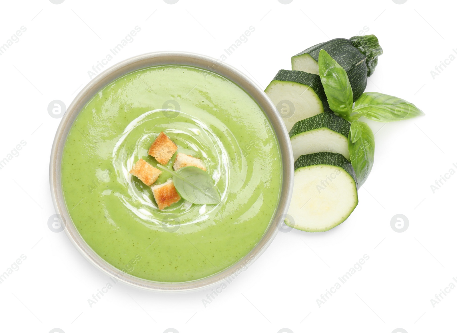 Photo of Tasty homemade zucchini cream soup isolated on white, top view