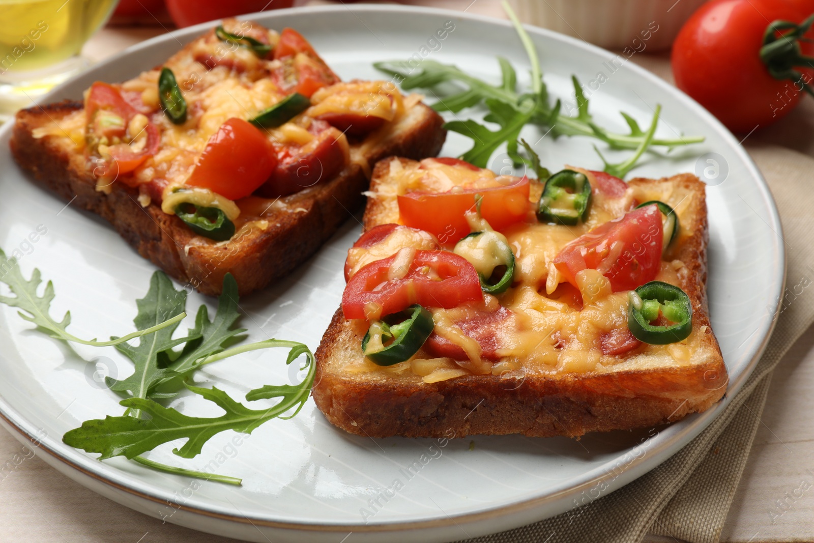 Photo of Tasty pizza toasts and ingredients on light wooden table, closeup